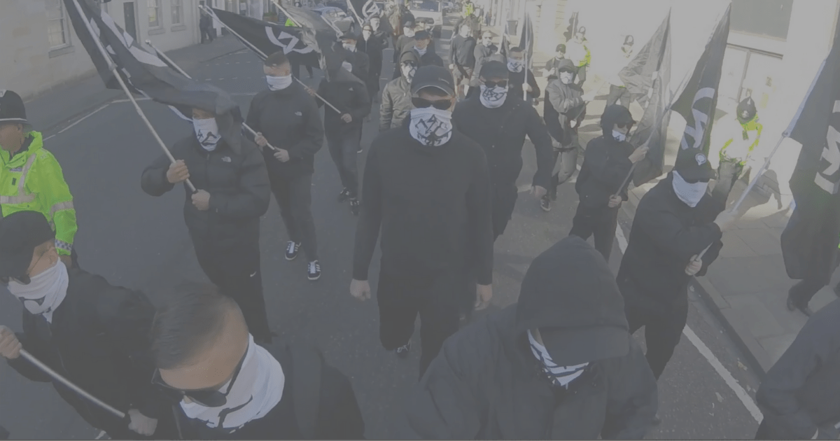 a faded image of National Action marching on the streets